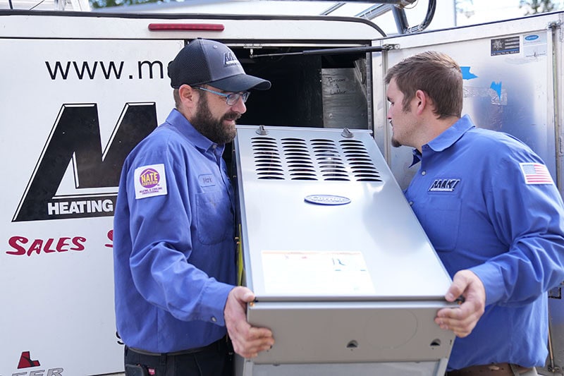 Maki Air team carrying furnace to van.