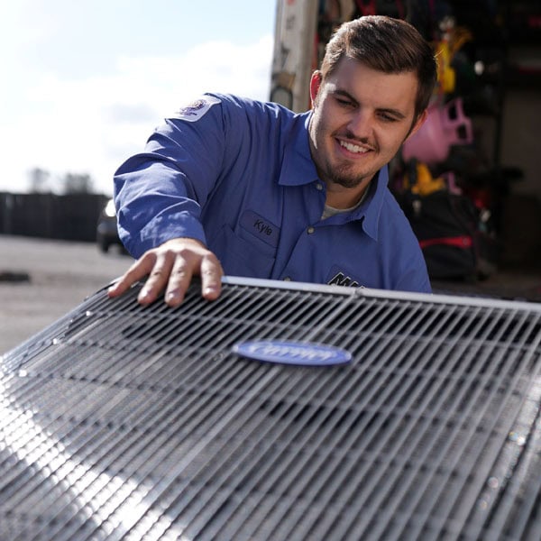 Maki Heating & Air Conditioning technician pulling out air conditioning unit from a van