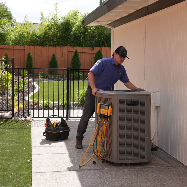 Maki Heating & Air Conditioning technician moving an outdoor air conditioning unit