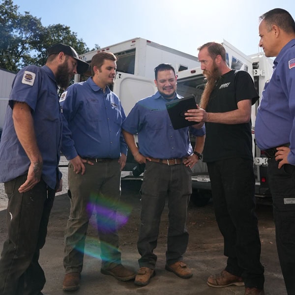 Maki Heating & Air Conditioning team grouped together talking and smiling