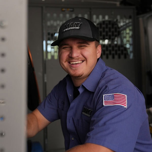 Maki Heating & Air Conditioning technician smiling inside company truck