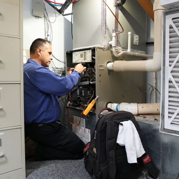 Maki Heating & Air Conditioning technician working on a gas furnace