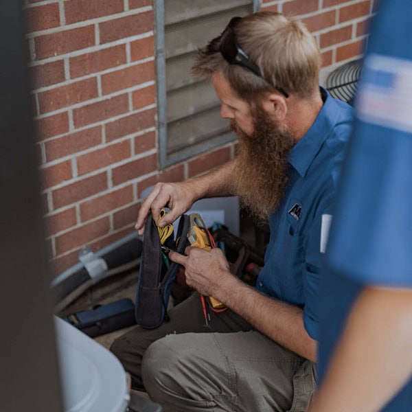 Maki Heating & Air Conditioning technician pulling tools from a tool bag