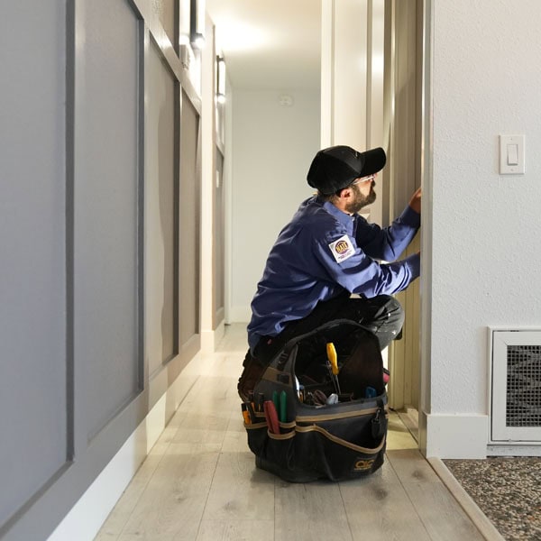 Maki Heating & Air Conditioning technician working on hallway closet heating unit