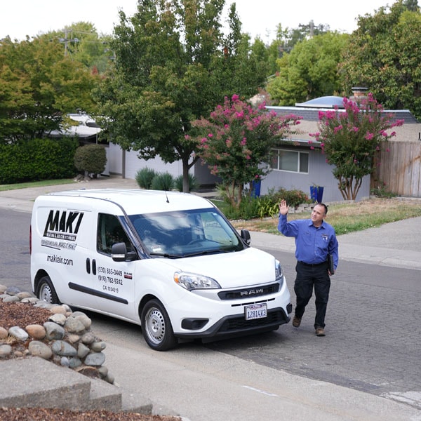 Maki Heating & Air Conditioning technician waving to customer in front of work truck